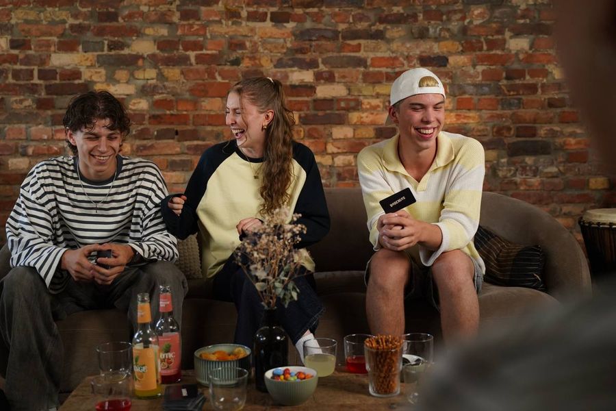 Gruppe im Wohnzimmer mit Karten in der Hand
