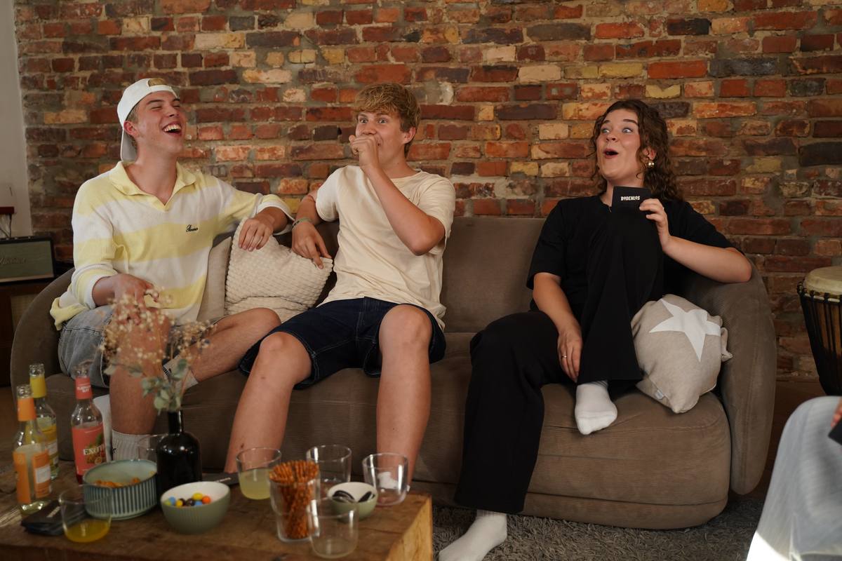 Drei Freunde lachen auf dem Sofa